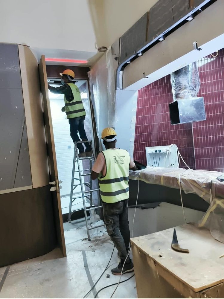Technicians working on a ceiling and doorway during a retail fit-out