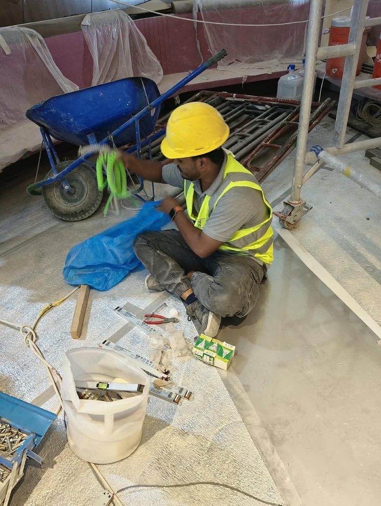 Technician preparing light fittings and wiring on site